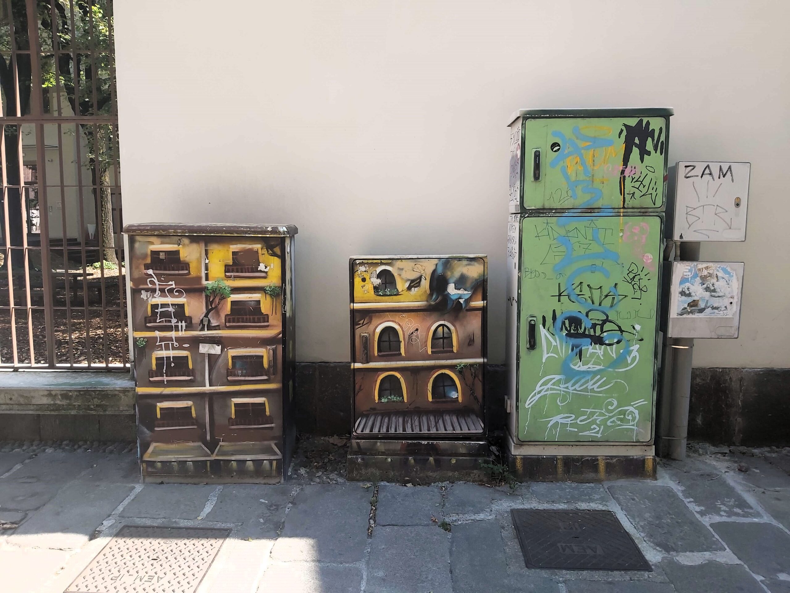 A graffiti image of buildings on utility units in Milan, Italy