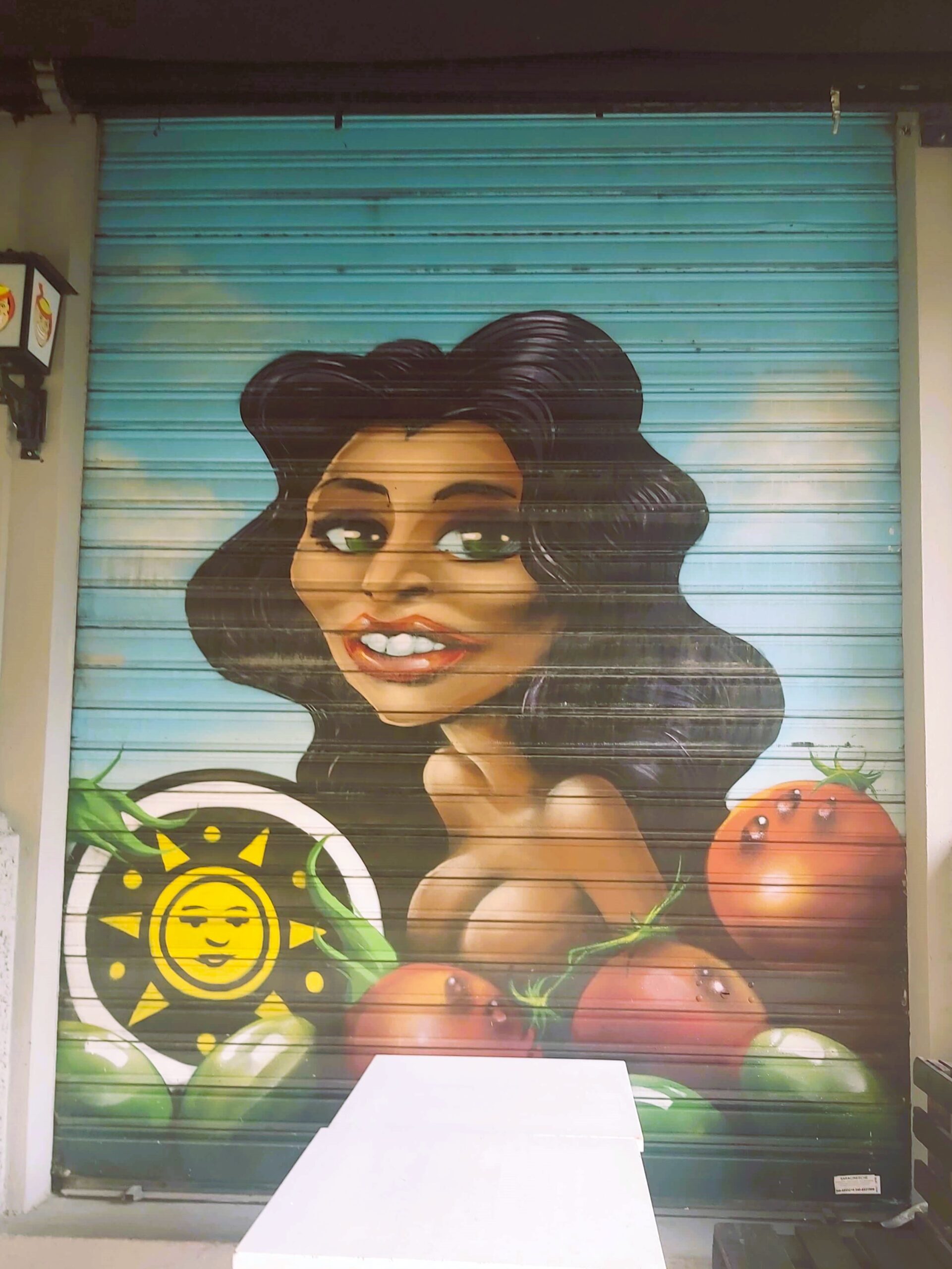 A graffiti image of a big breasted woman with tomatoes in Milan, Italy