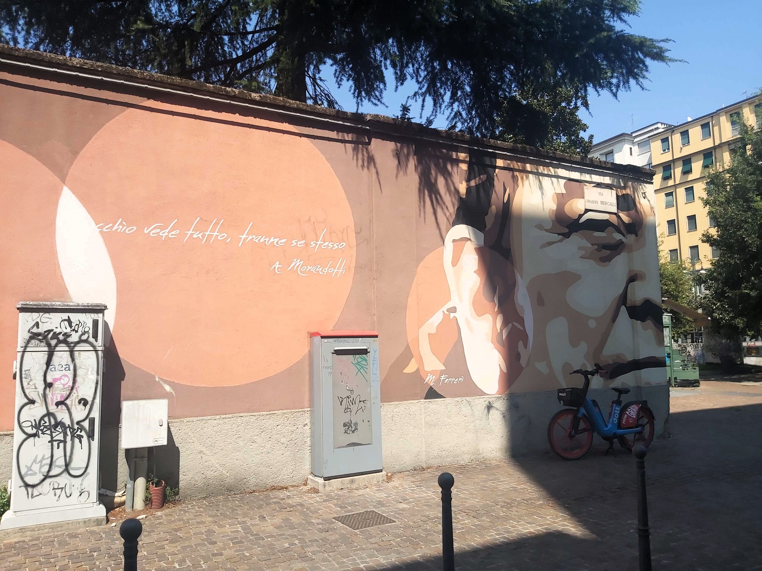A graffiti image of a man's face and a quote in Milan, Italy