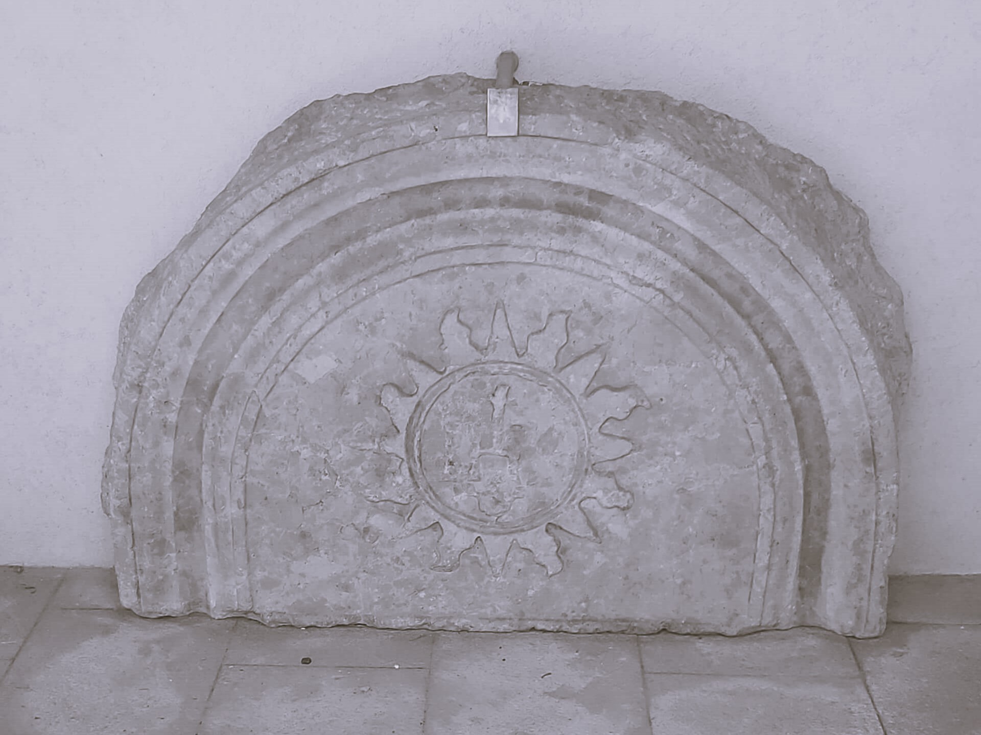 A partial ancient stone slab with a sunburst shape on it. Rijeka, Croatia