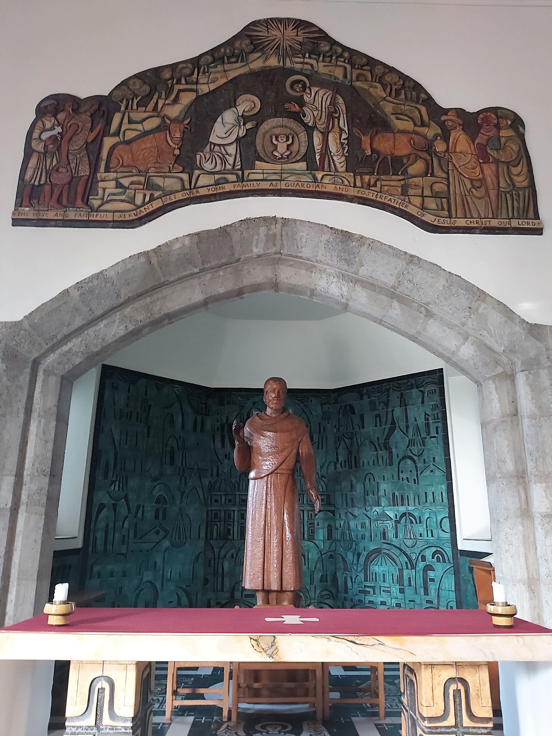 A turquoise background and statue at an altar in The Friars Aylesford Priory, Kent, England