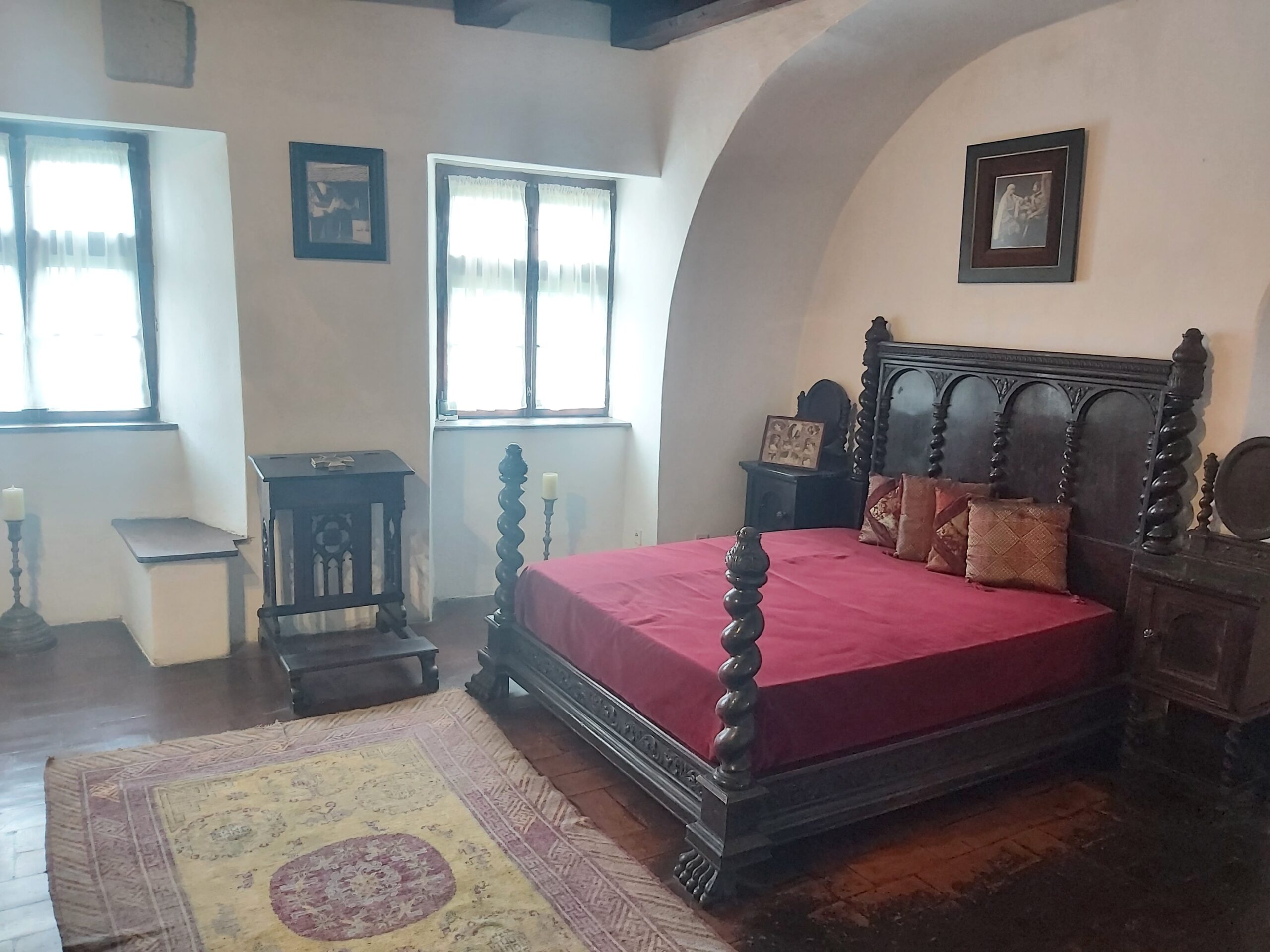 An ornate wooden bed with mat in a bedroom at Bran Castle, Romania