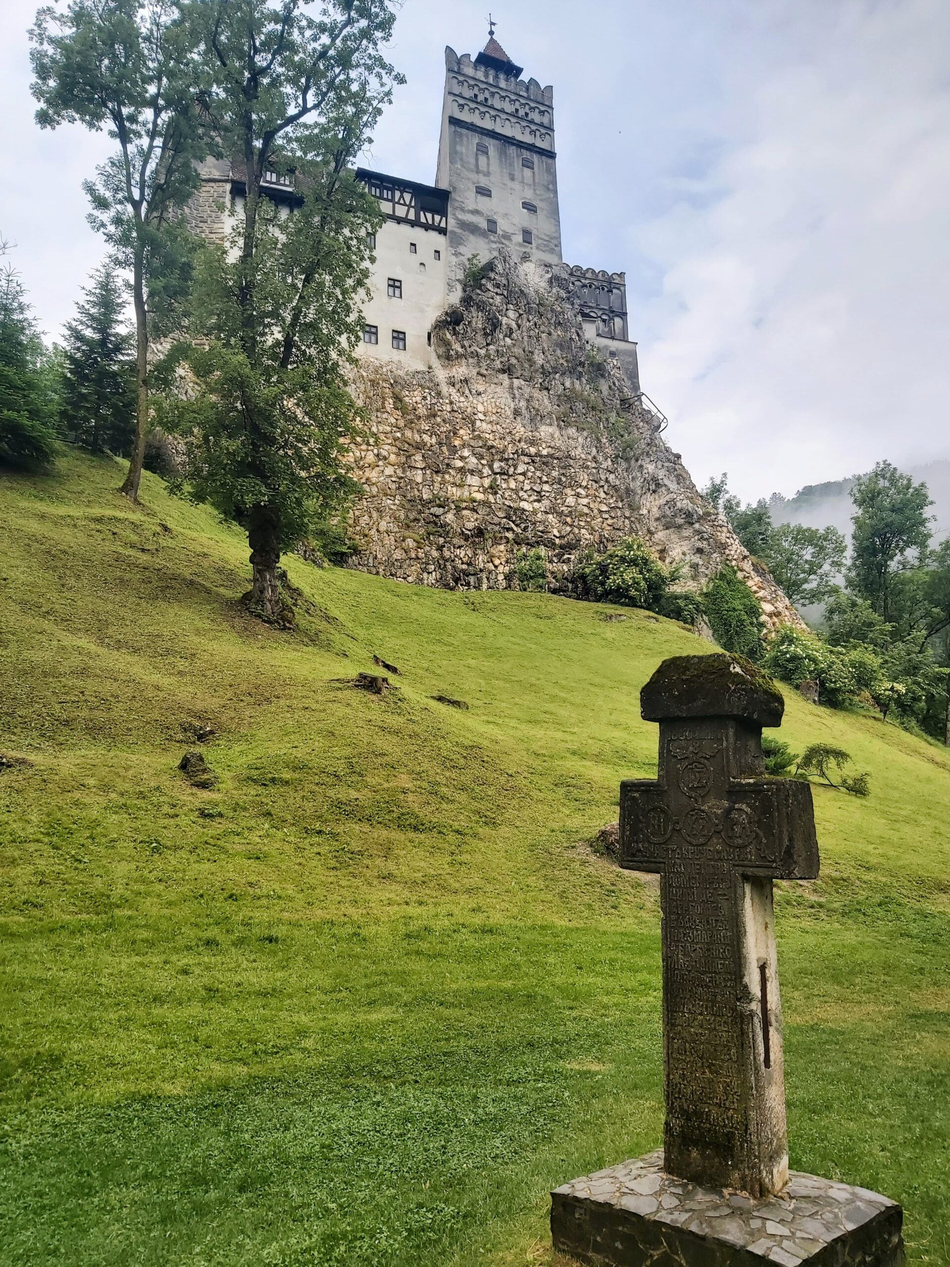 A cross with Bran Castle in the background, Bran, Romania