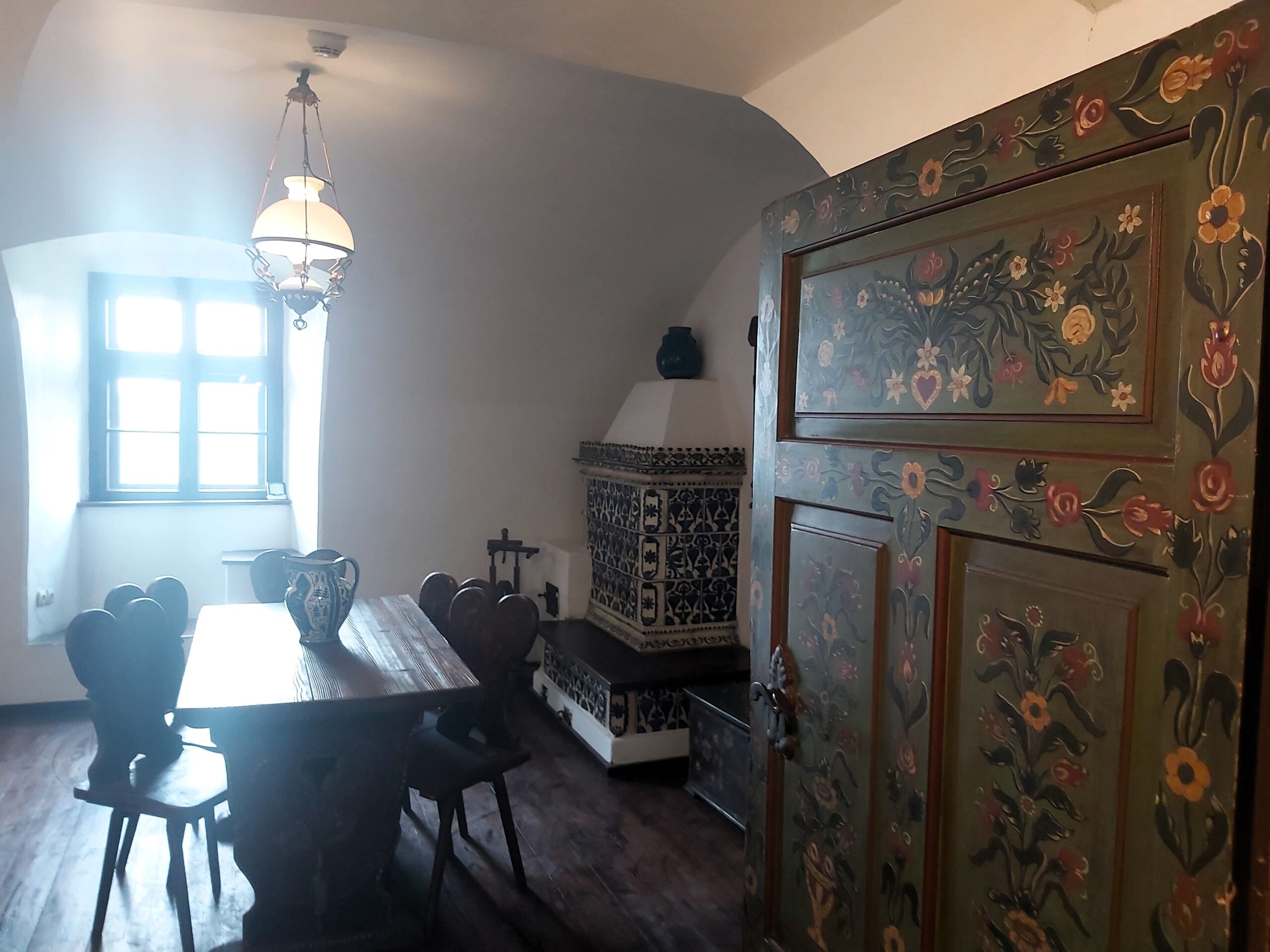 A view into a dining room with a traditionally painted door in Bran Castle, Romania