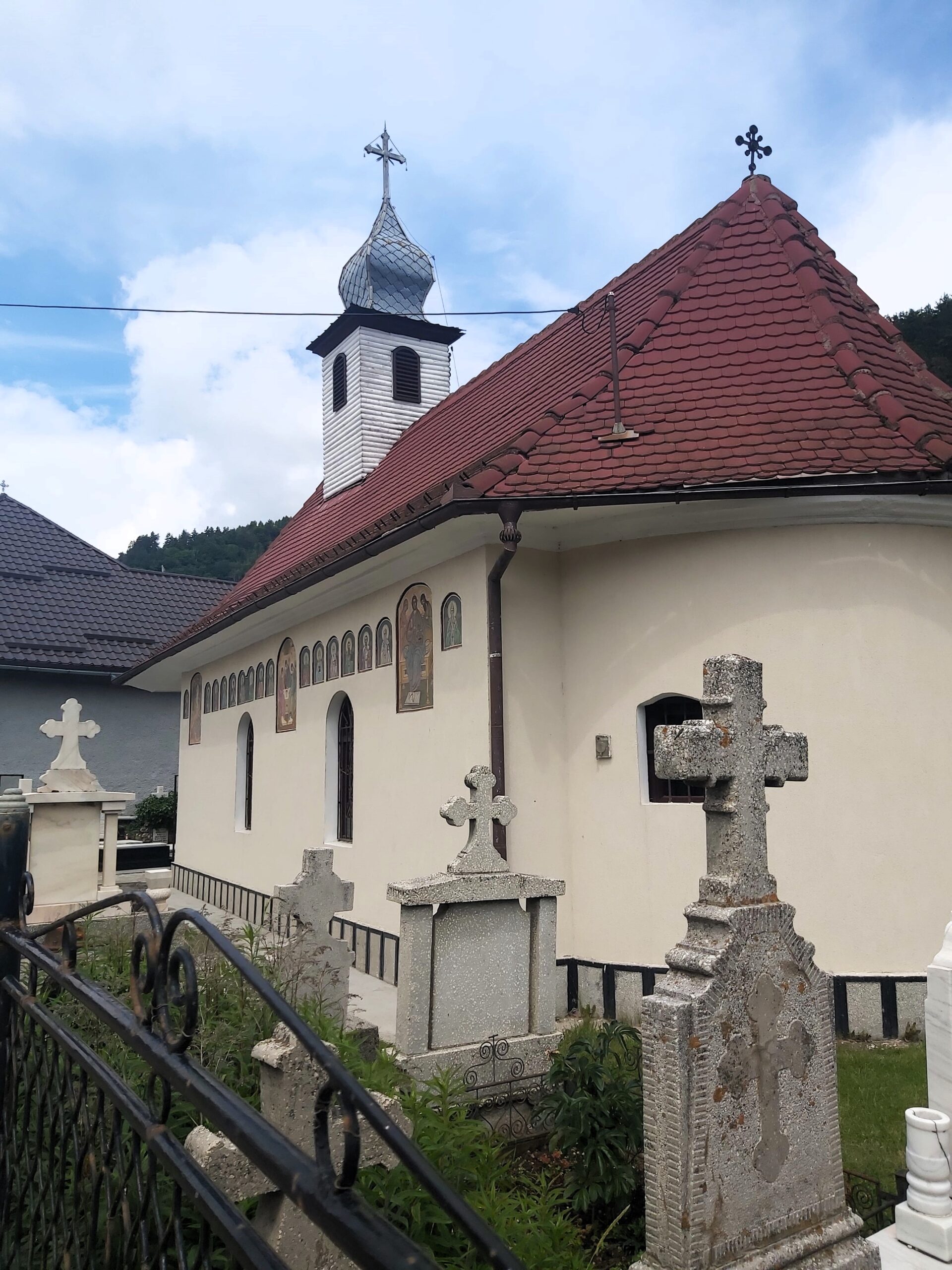A small white church and graves in Bran, Romania