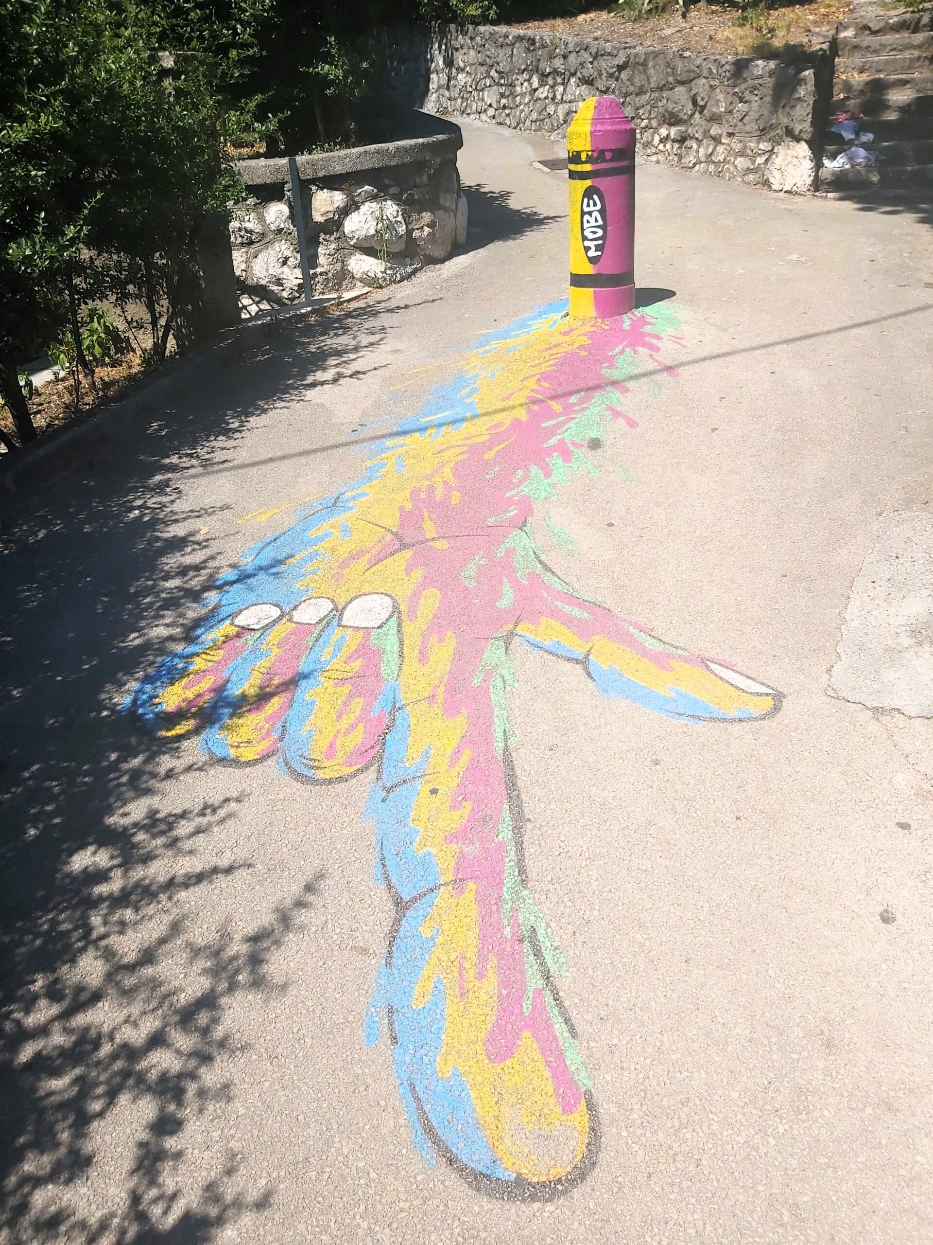 A multi-coloured hand painted on the floor, pointing to the beach, Rijeka, Croatia