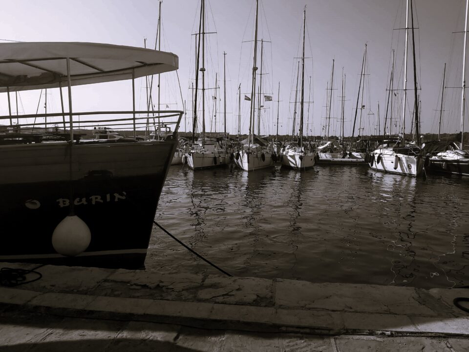A black and white shot of boats in the harbour at Pula, Croatia