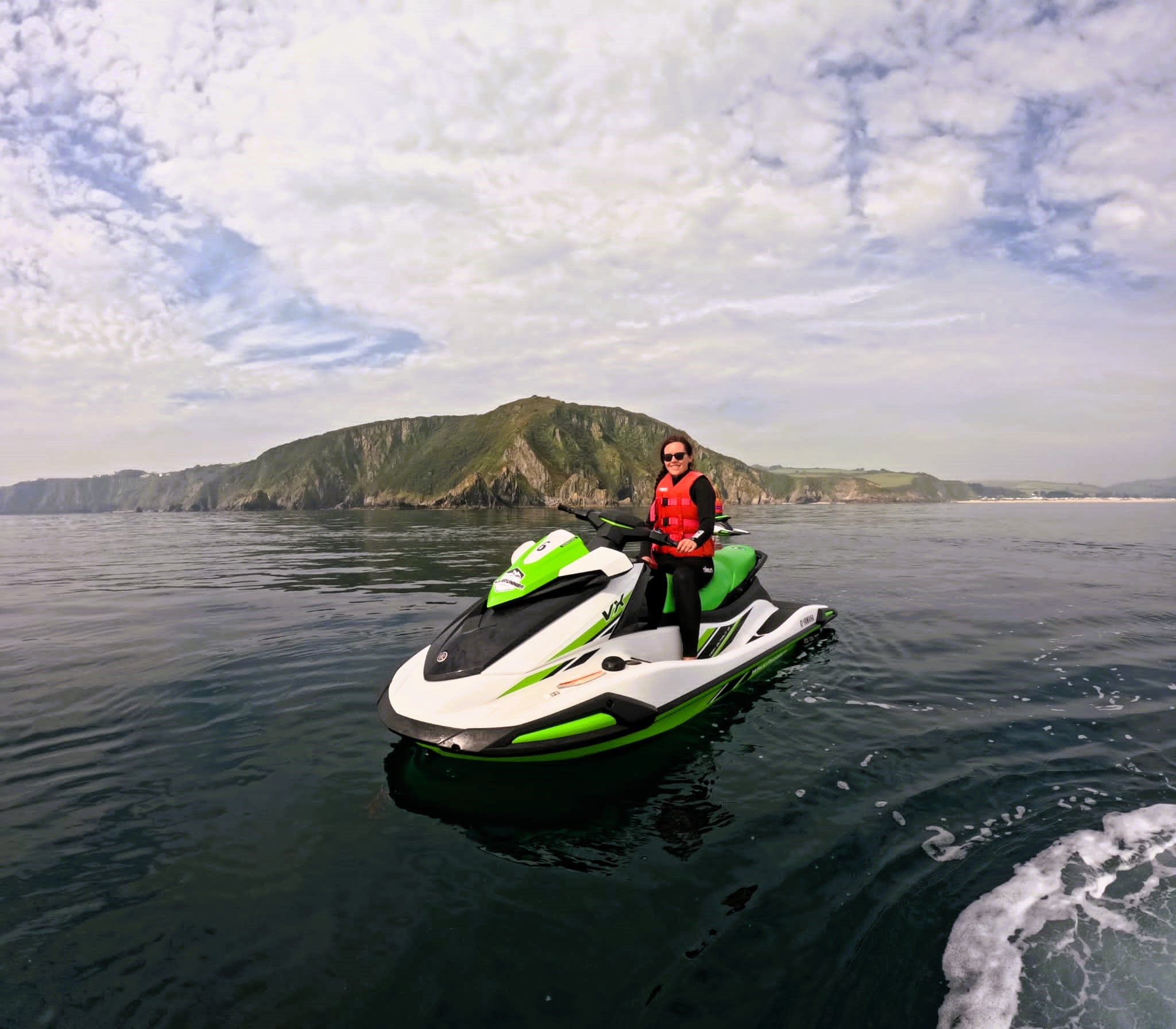 Wandering Lewis on a green and white jet-ski in Carlyon bay, Cornwall, England