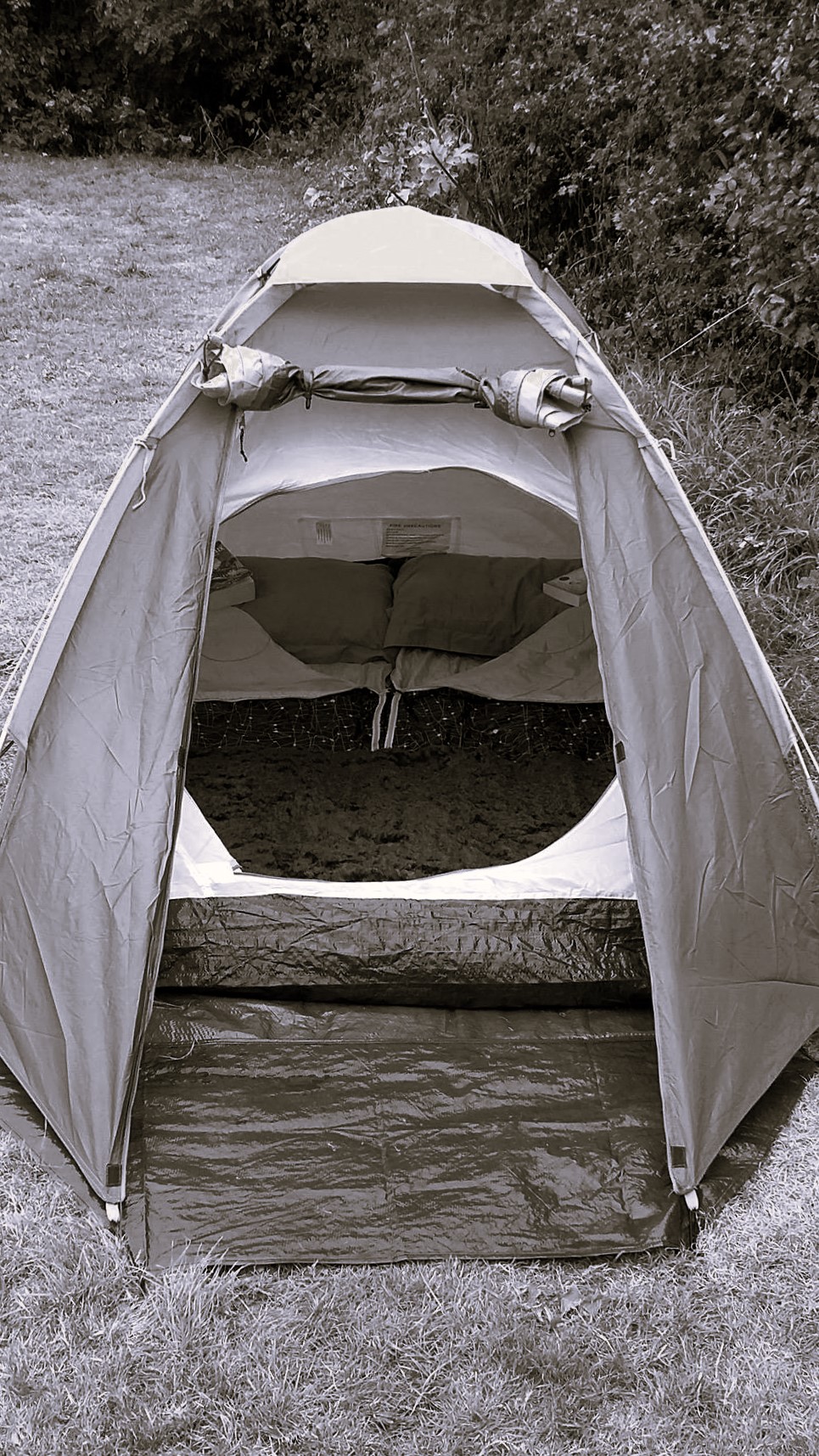 a black and white shot showing the cosy inside of a small tent
