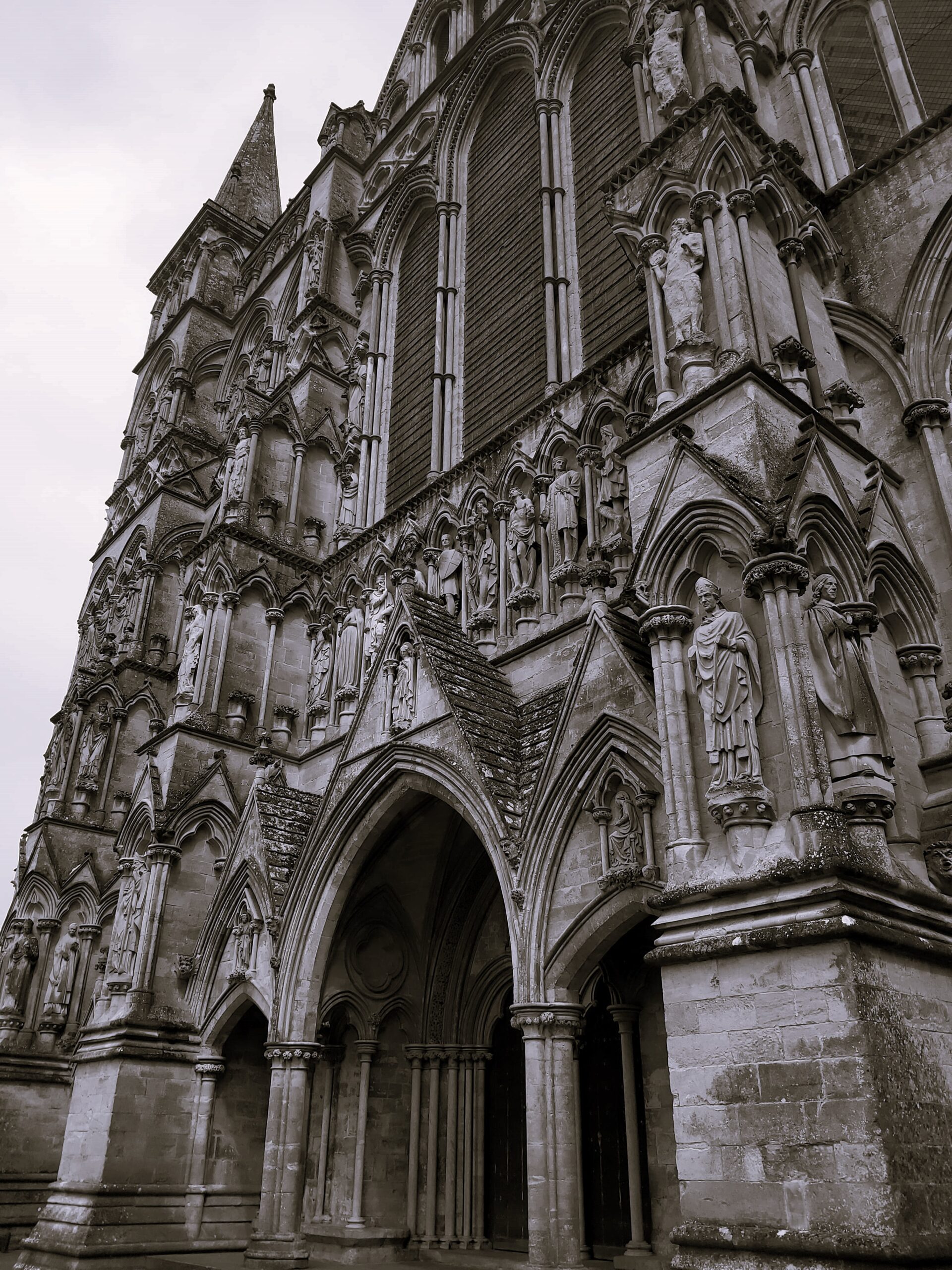 A moody black and white shot of an entrance to Winchester Cathedral, England