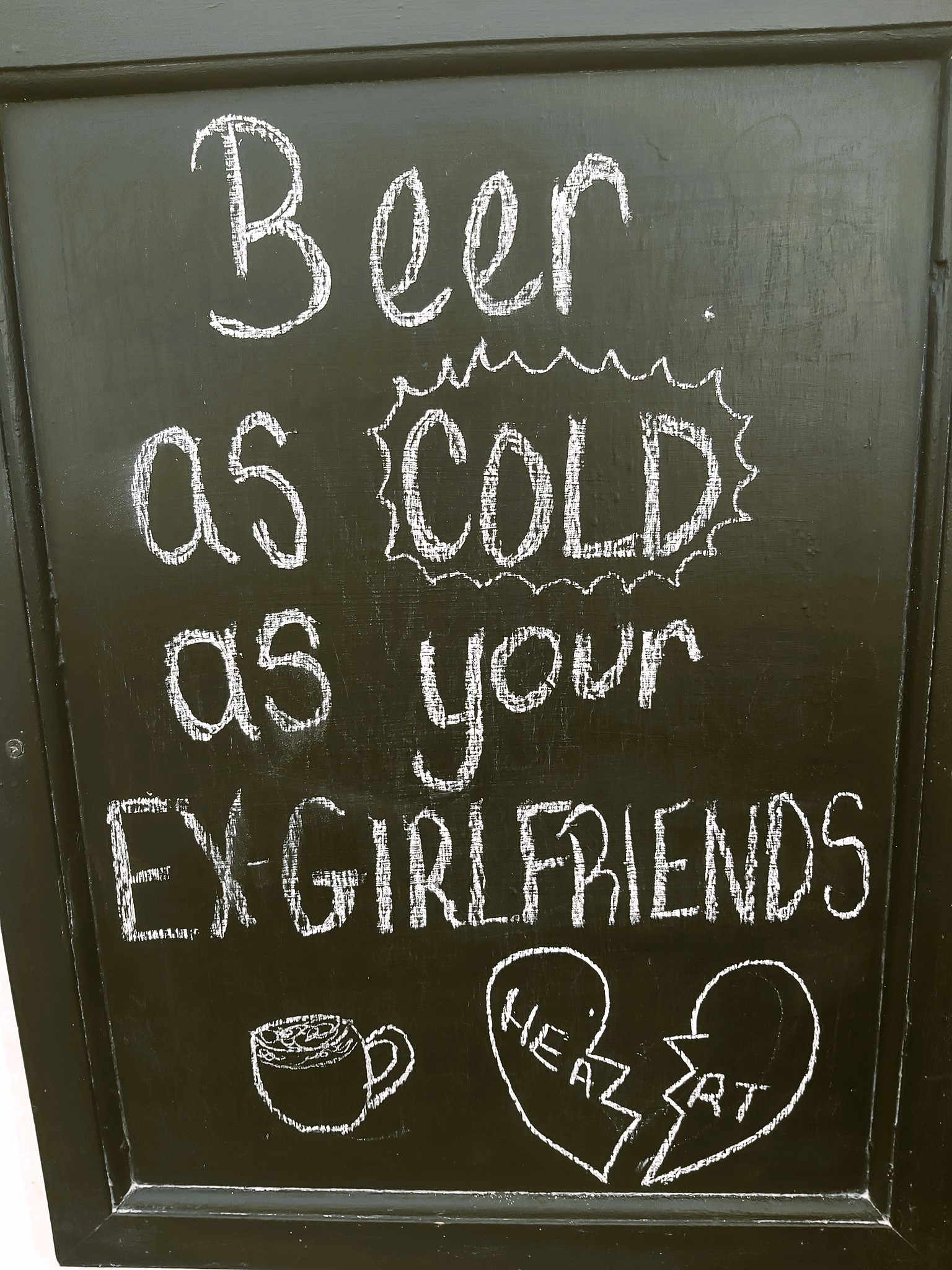 A sign reading "beer as cold as your ex-girlfriends heart" in Beer, Devon, England.