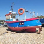 Blue and red boat moored on the beach in Hastings, England