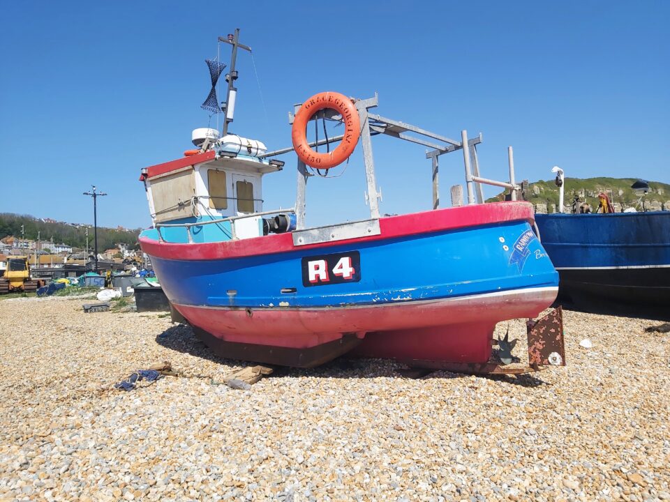 Blue and red boat moored on the beach in Hastings, England