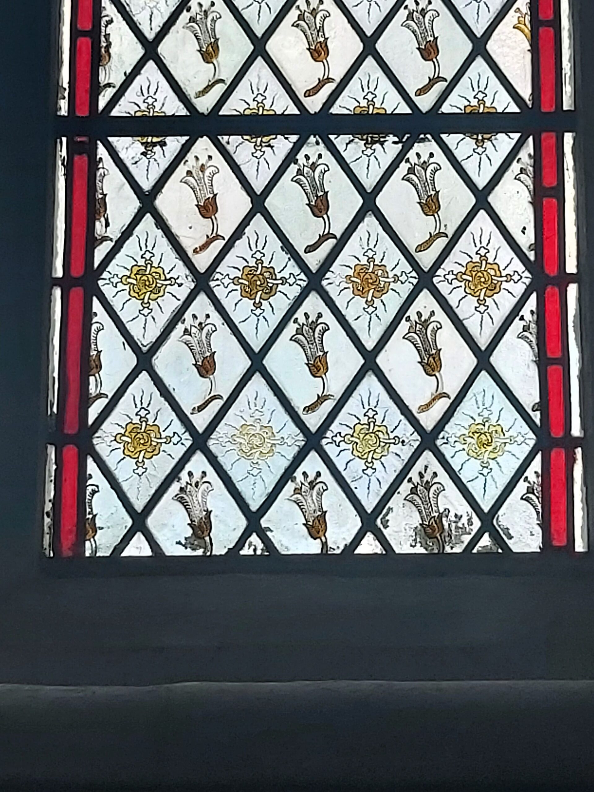 Small flowers and crosses pattern on a stained glass window in St Mary's Church, Ware, England