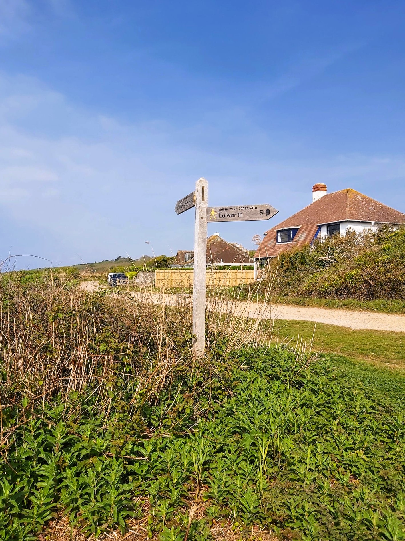 A signpost to Lulworth cove, seen at Ringstead Beach, Dorset, England.