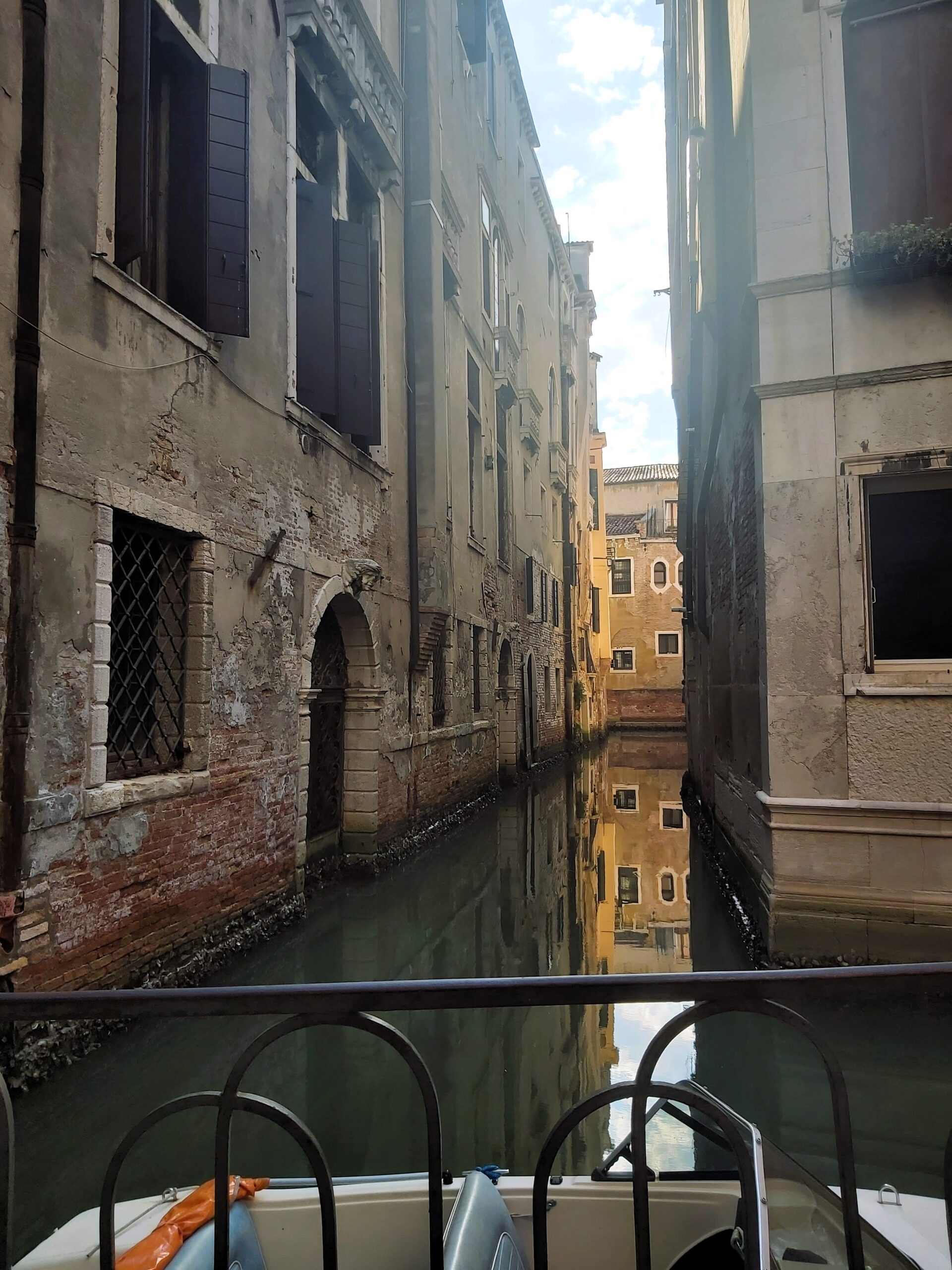 A still reflection of a building on a calm canal in Venice, Italy