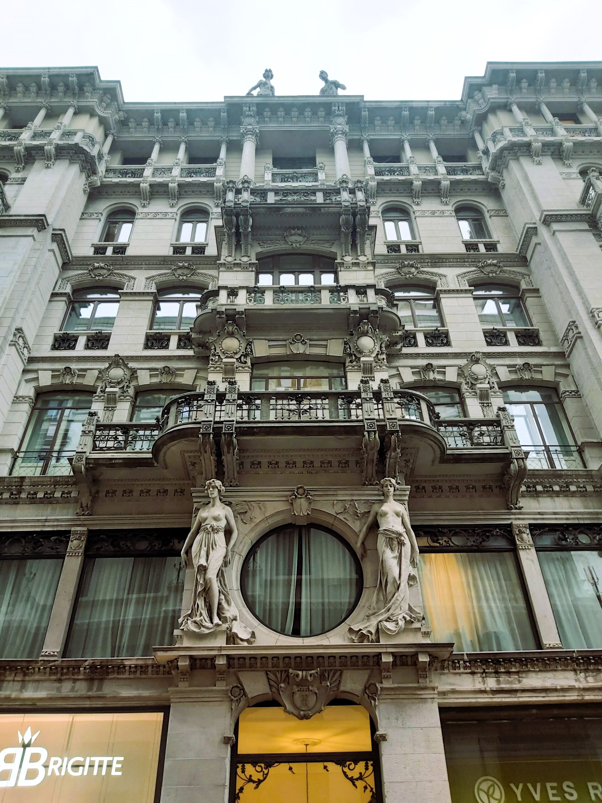 Statuettes on a building above a shop front, Trieste, Italy