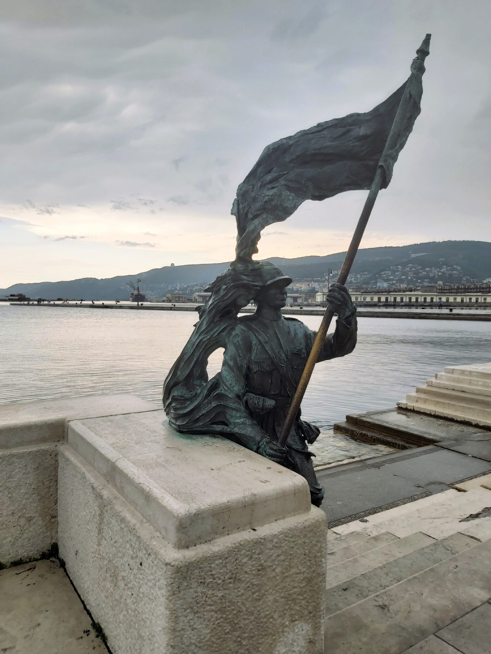 A statue of a soldier holding a flag in Trieste, Italy