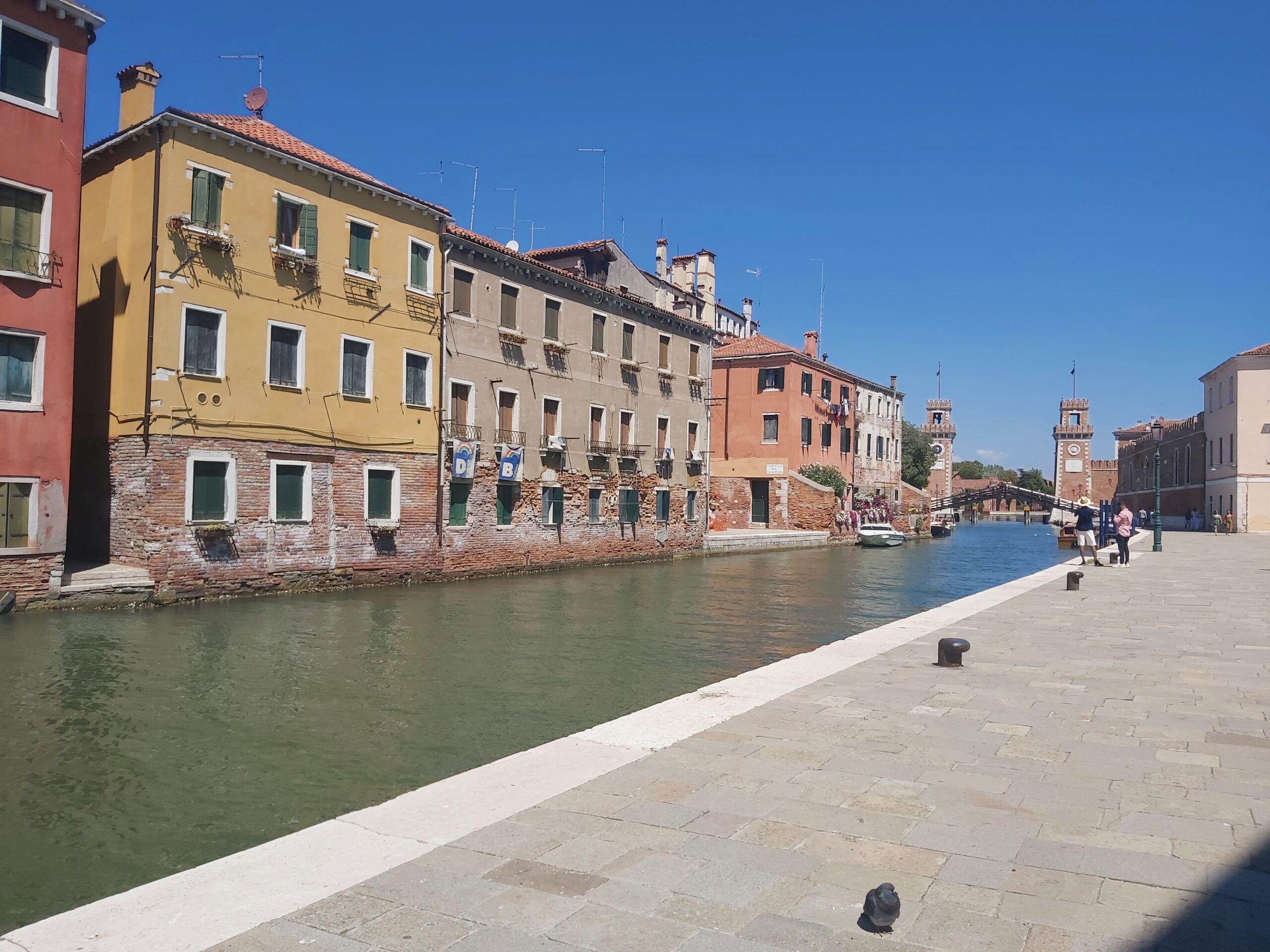 A canal view with The Venetian Arsenal and colourful buildings in Venice, Italy