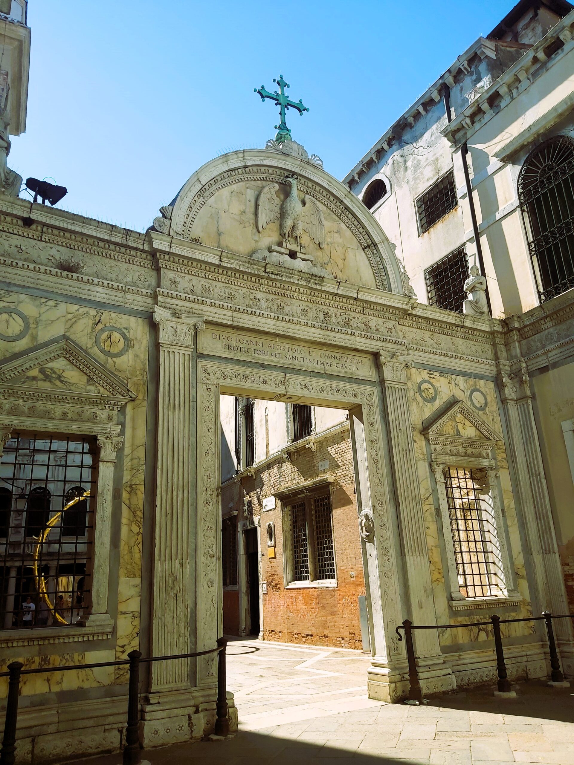 An ornate doorway with an eagle and cross above it in Venice, Italy