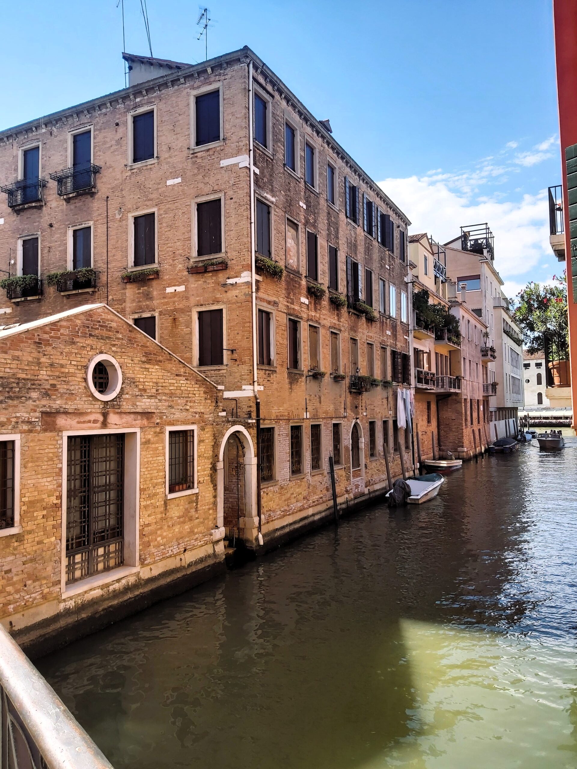 A view of a canal and a selection of brick buildings in Venice, Italy
