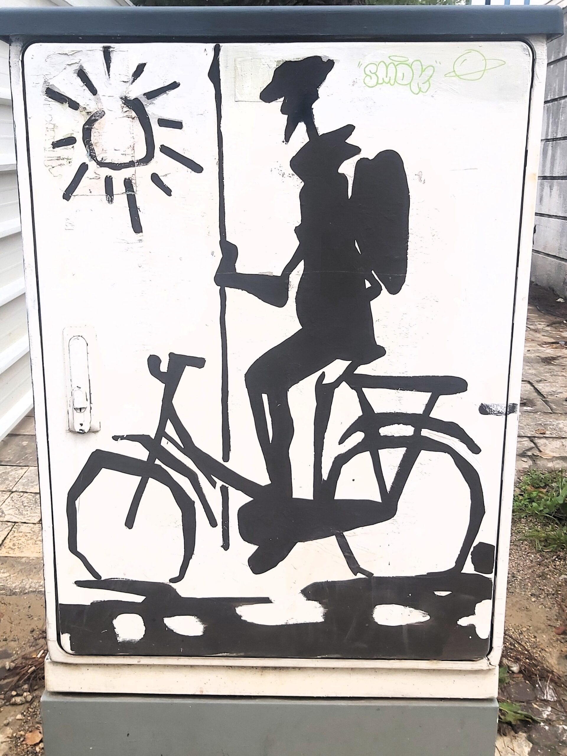 A black and white image of a cyclist on a utilities box in Tirana, Albania