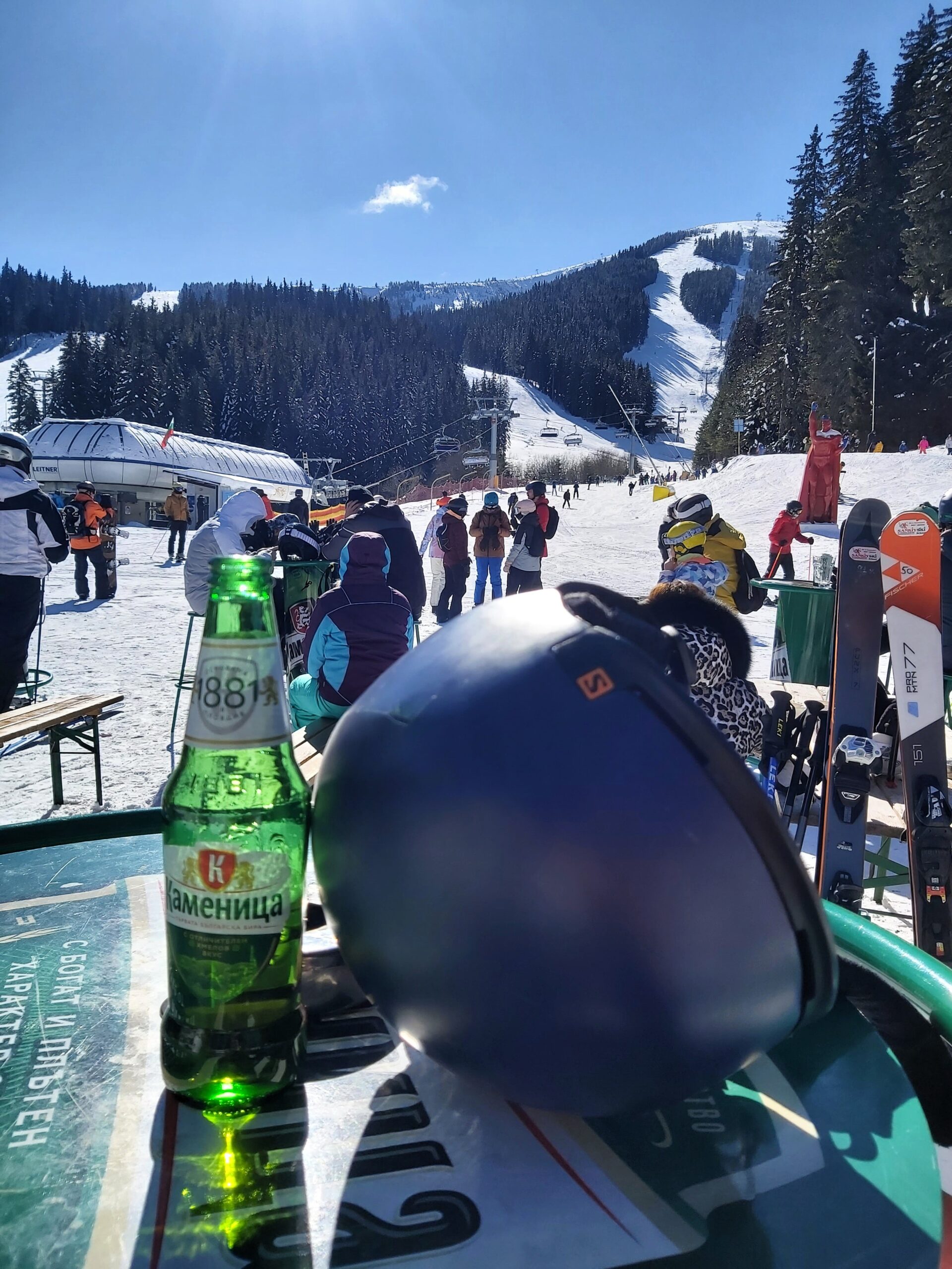 A view of the slopes, a helmet and a beer in Bansko, Bulgaria
