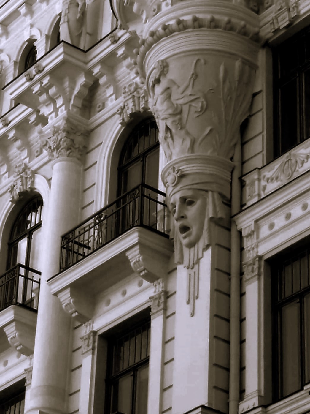 A haunting fascia on an art nouveau style building in Riga, Latvia, depicting a blank-eyed, open-mouthed face.